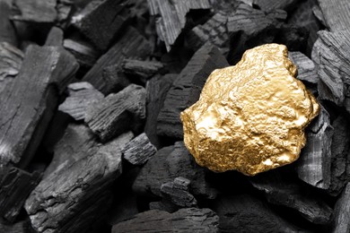 Shiny gold nugget on coals, closeup view