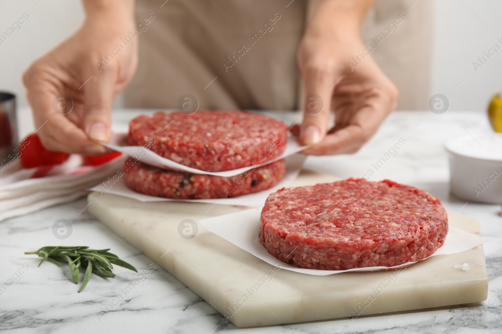 Photo of Woman making hamburger patties at white marble table, closeup