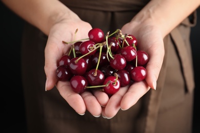 Photo of Woman holding sweet juicy cherries, closeup view