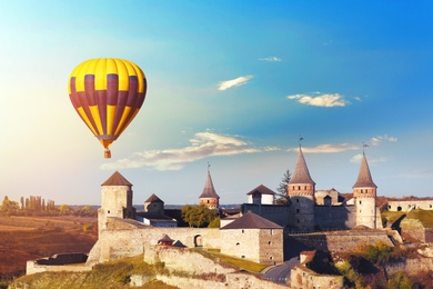 Photo of KAMIANETS-PODILSKYI, UKRAINE - OCTOBER 06, 2018: Beautiful viewhot air balloon flying near Kamianets-Podilskyi Castle