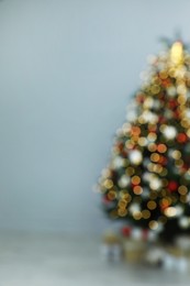 Blurred view of beautifully decorated Christmas tree in room, space for text