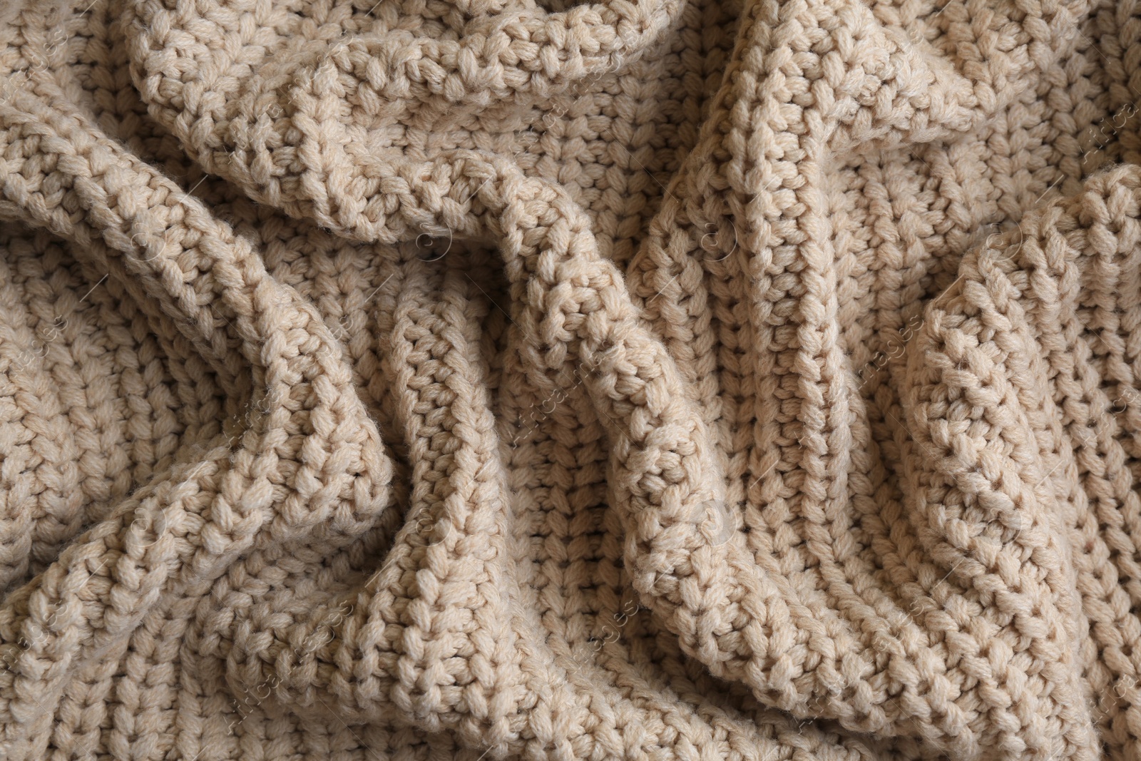 Photo of Beautiful beige knitted fabric as background, top view