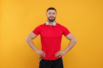 Photo of Handsome man with headphones on yellow background