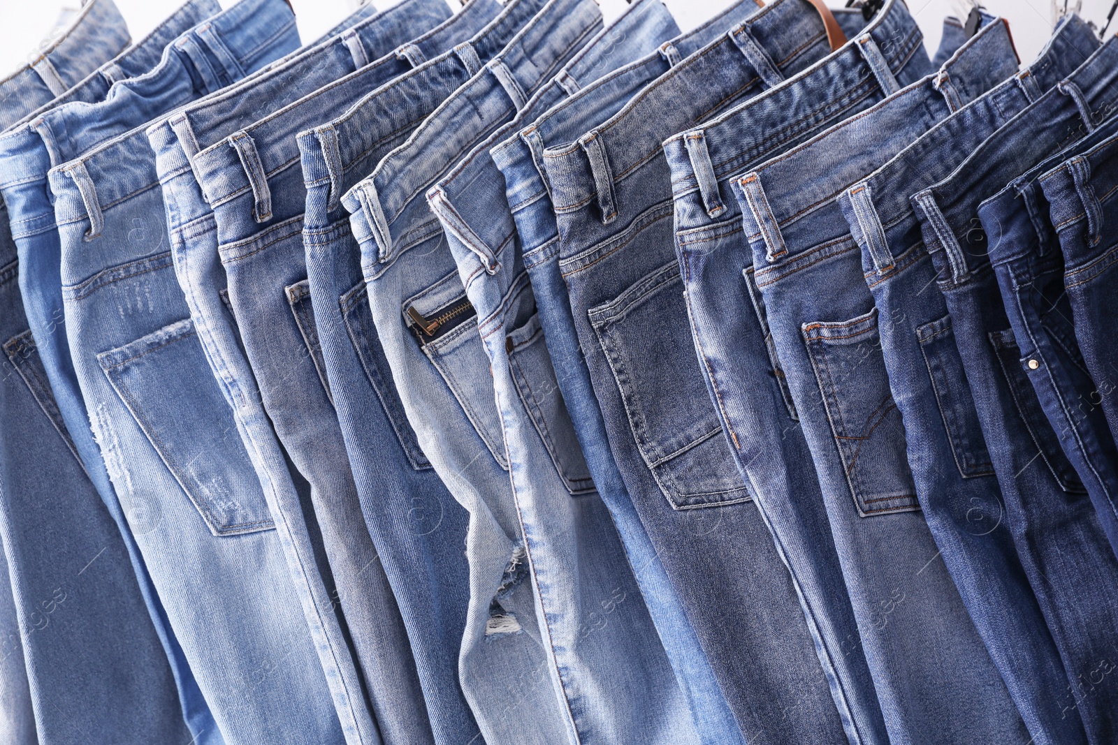 Photo of Closeup view of rack with different jeans