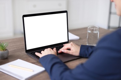 Photo of Woman watching webinar at wooden table in office, closeup