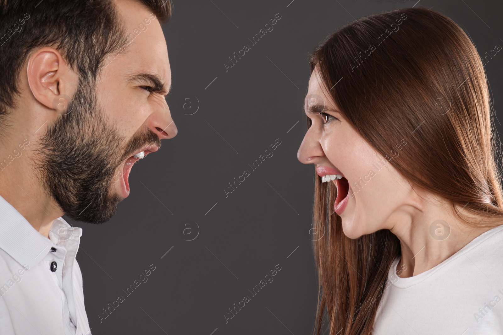 Photo of Couple quarreling on black background, closeup. Relationship problems