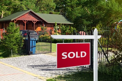 Image of Red Sold sign near beautiful house outdoors