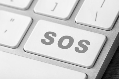 Image of Button with word SOS on computer keyboard, closeup. Rescue concept