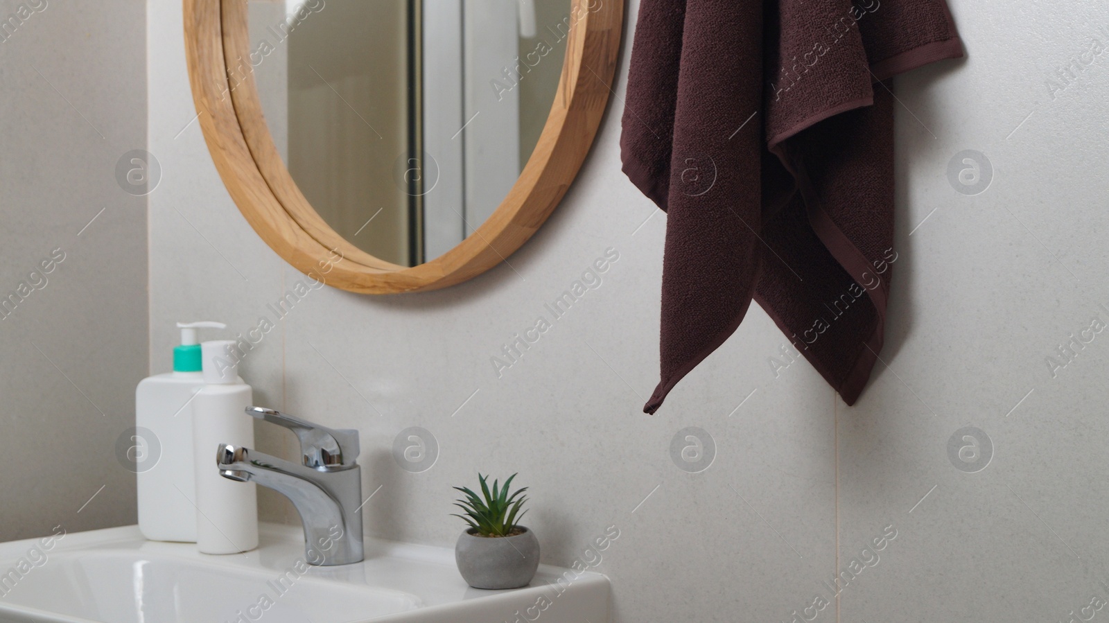 Photo of Brown soft towel hanging on grey wall in bathroom