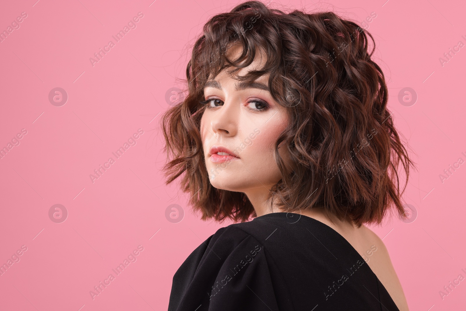 Photo of Portrait of beautiful young woman with wavy hairstyle on pink background. Space for text