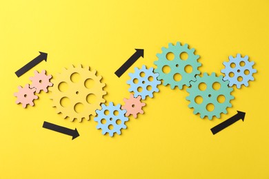 Business process organization and optimization. Scheme with wooden figures and arrows on yellow background, top view