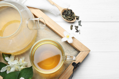 Photo of Flat lay composition with tea and fresh jasmine flowers on white wooden table