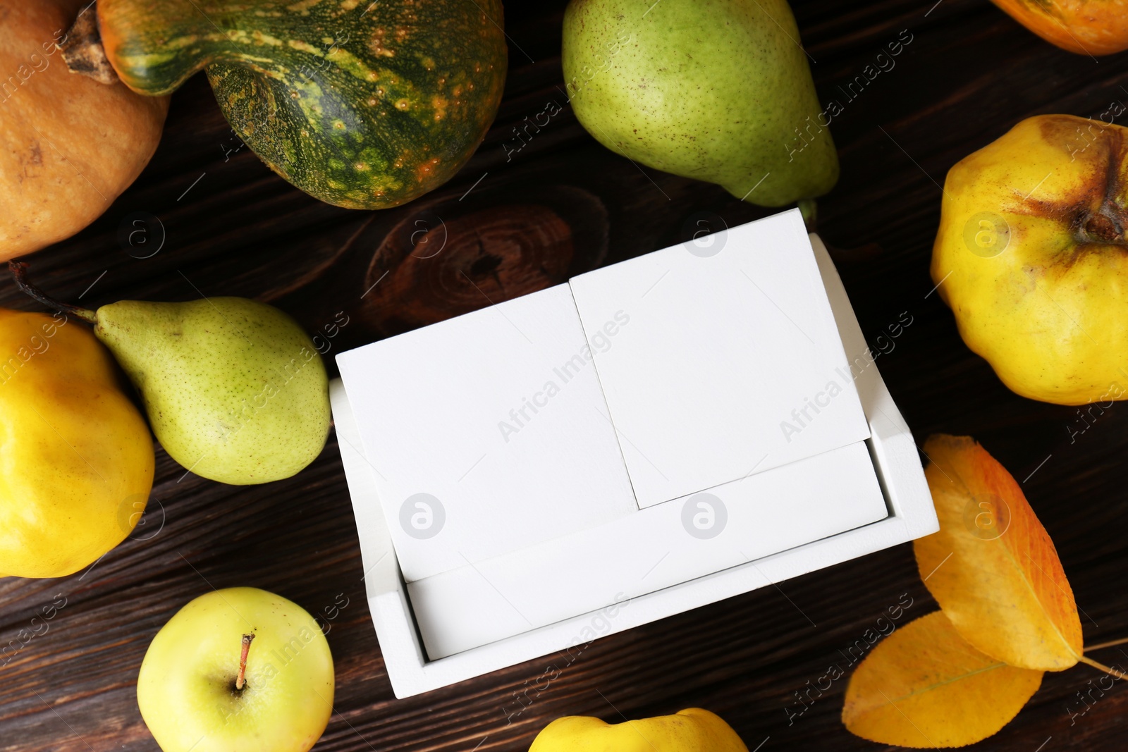 Photo of Thanksgiving day, holiday celebrated every fourth Thursday in November. Block calendar, fruits, vegetables and autumn leaves on wooden table, flat lay