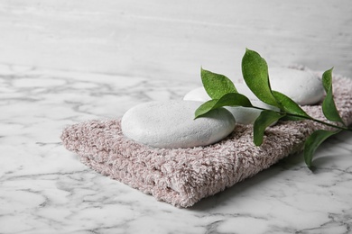 Photo of Beautiful composition with spa stones and towel on table