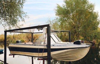 Photo of Modern boat hanging over river on autumn day