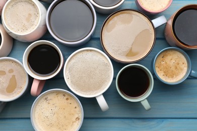 Photo of Many cups of different coffee drinks on light blue wooden table, flat lay