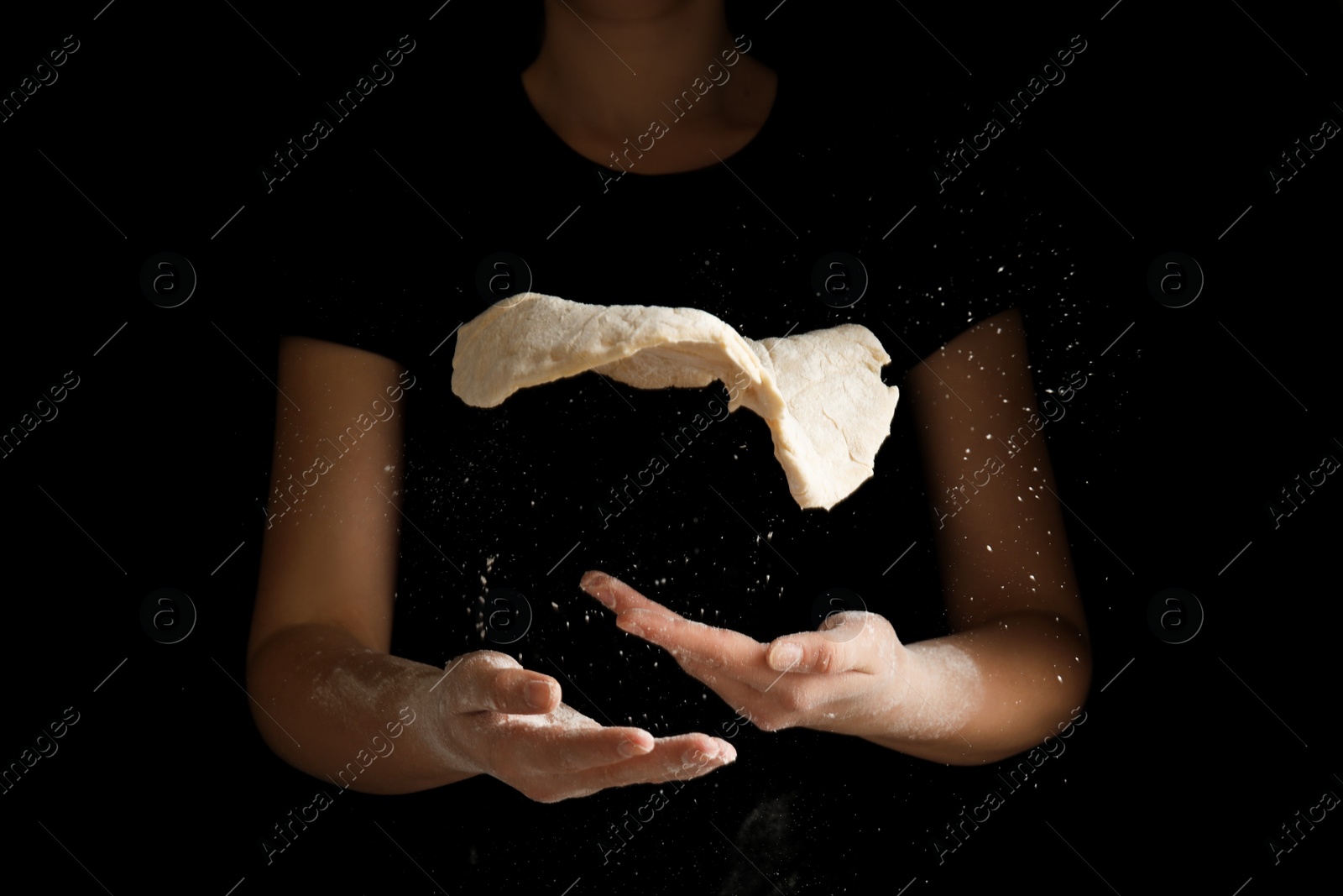 Photo of Woman preparing dough for pizza on black background, closeup