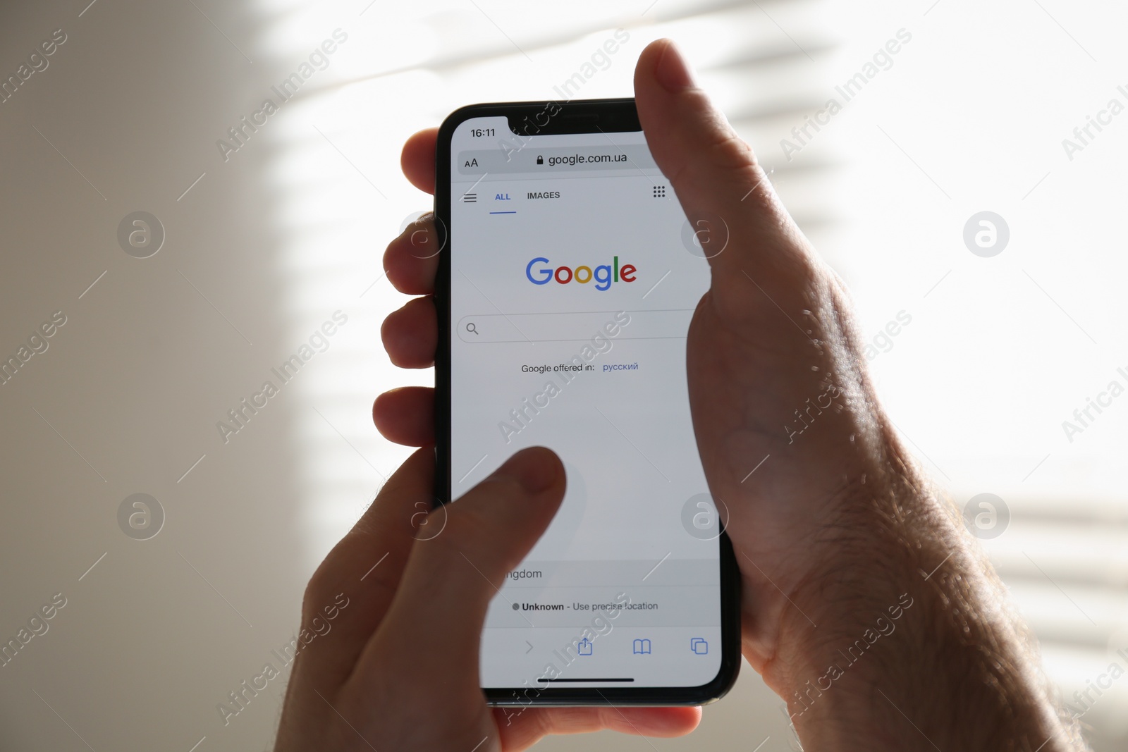 Photo of MYKOLAIV, UKRAINE - OCTOBER 27, 2020: Man using Google search engine on smartphone against blurred background, closeup