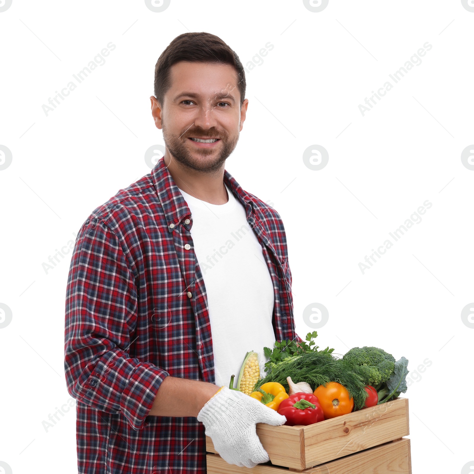 Photo of Harvesting season. Happy farmer holding wooden crate with vegetables on white background