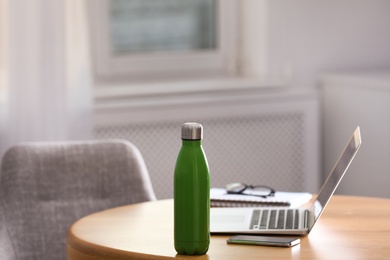 Photo of Thermo bottle on table in modern office