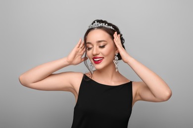 Photo of Beautiful young woman wearing luxurious tiara on light grey background