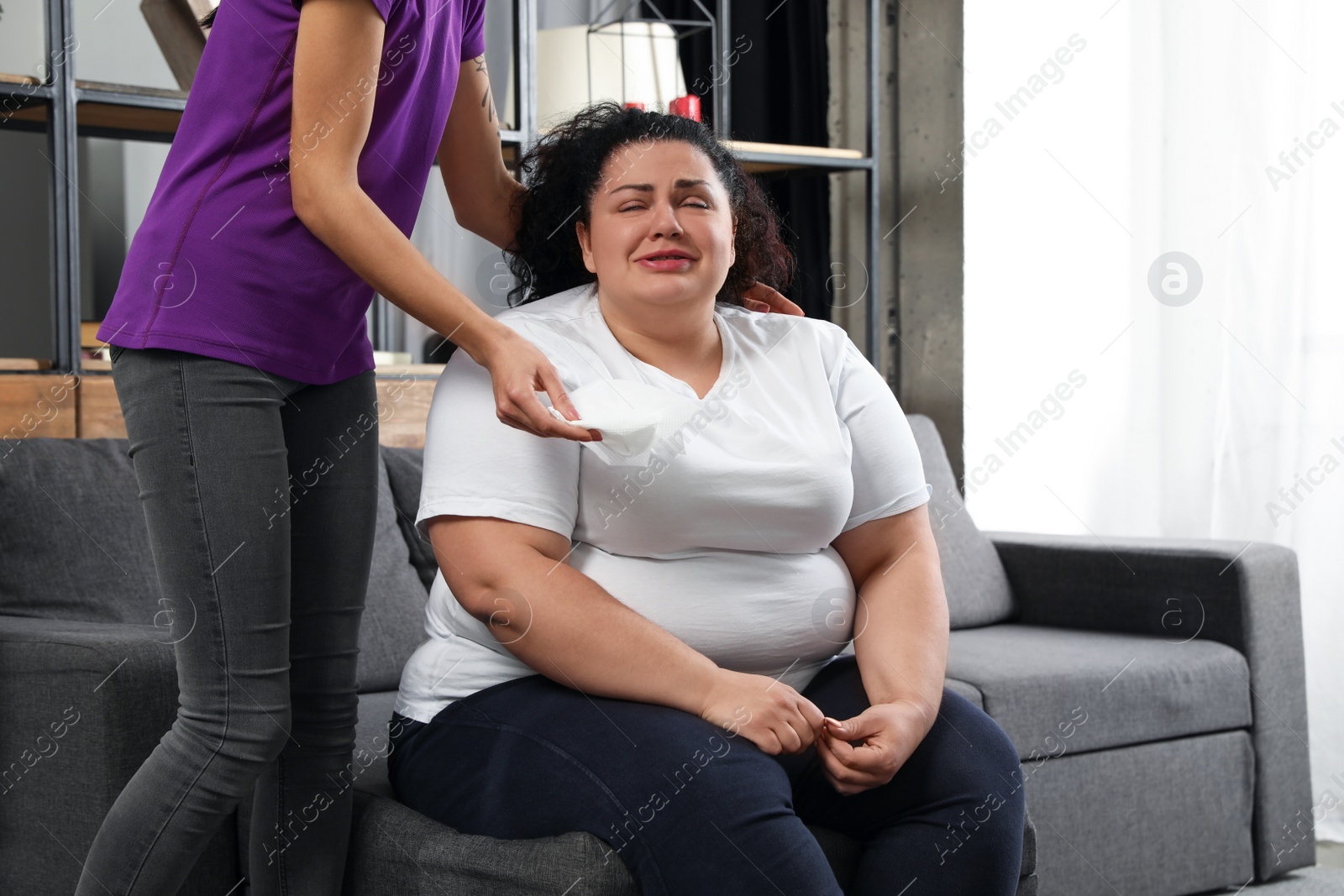 Photo of Woman comforting her depressed overweight friend at home