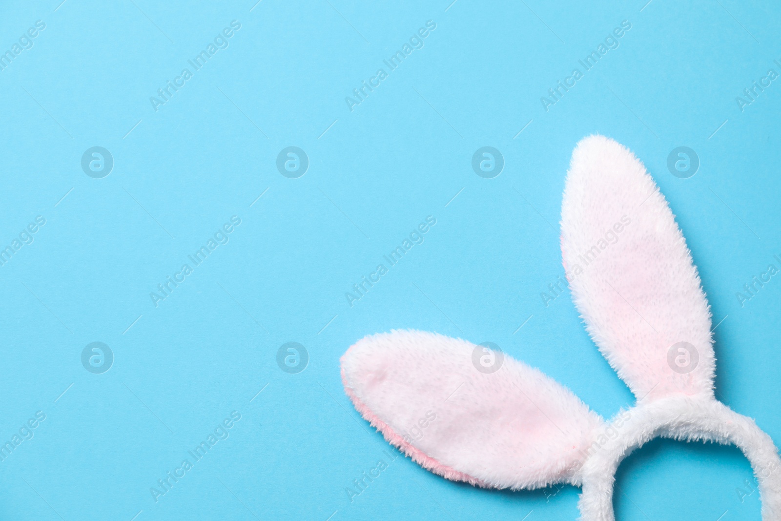 Photo of Funny headband with Easter bunny ears on color background, top view. Space for text