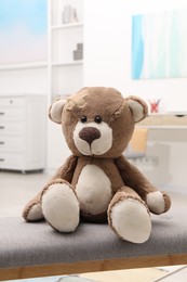 Photo of Toy cute bear with sticking plaster indoors