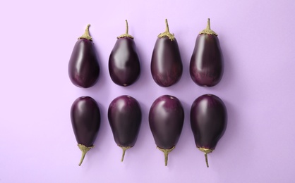 Photo of Raw ripe eggplants on light background, flat lay