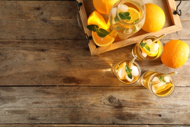 Photo of Delicious refreshing drink with orange slices on wooden table, flat lay. Space for text