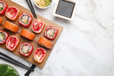 Photo of Flat lay composition with delicious sushi rolls on white marble table. Space for text