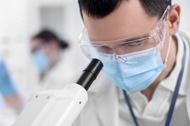 Photo of Scientist working with microscope in laboratory, closeup