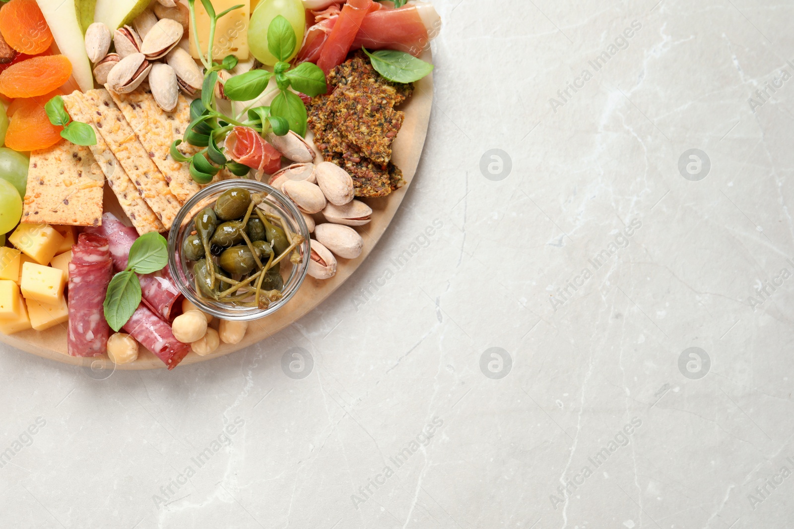 Photo of Different tasty appetizers on light table, top view. Space for text