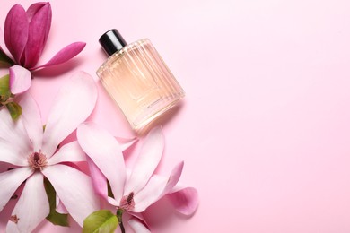 Photo of Beautiful magnolia flowers and bottle of perfume on pink background, flat lay. Space for text