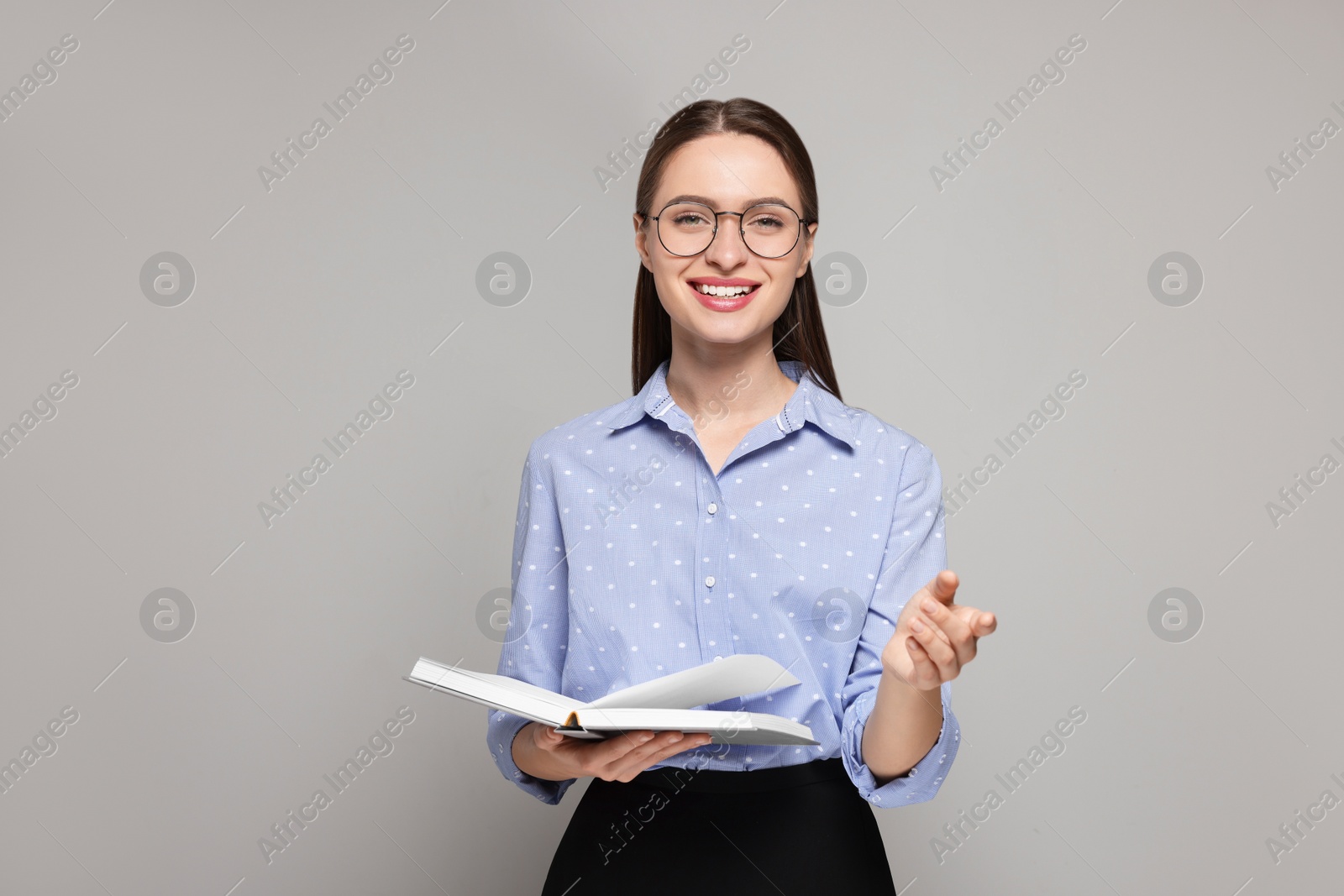 Photo of Portrait of beautiful young teacher on grey background