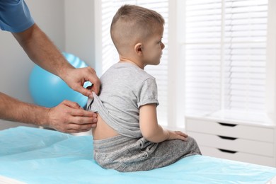 Photo of Orthopedist examining child's back in clinic, closeup. Scoliosis treatment