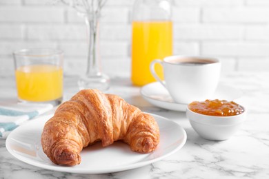 Photo of Tasty breakfast. Fresh croissant and jam on white marble table