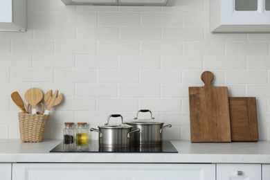 Photo of Counter with set of dishware and utensils in stylish kitchen interior