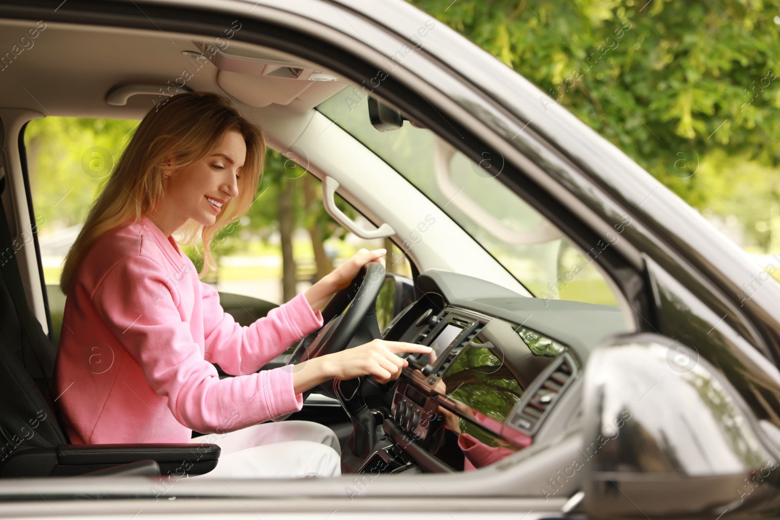 Photo of Young woman using navigation system while driving car