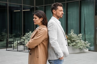 Upset arguing couple near building outdoors. Relationship problems