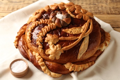 Photo of Korovai on tablecloth, closeup. Ukrainian bread and salt welcoming tradition