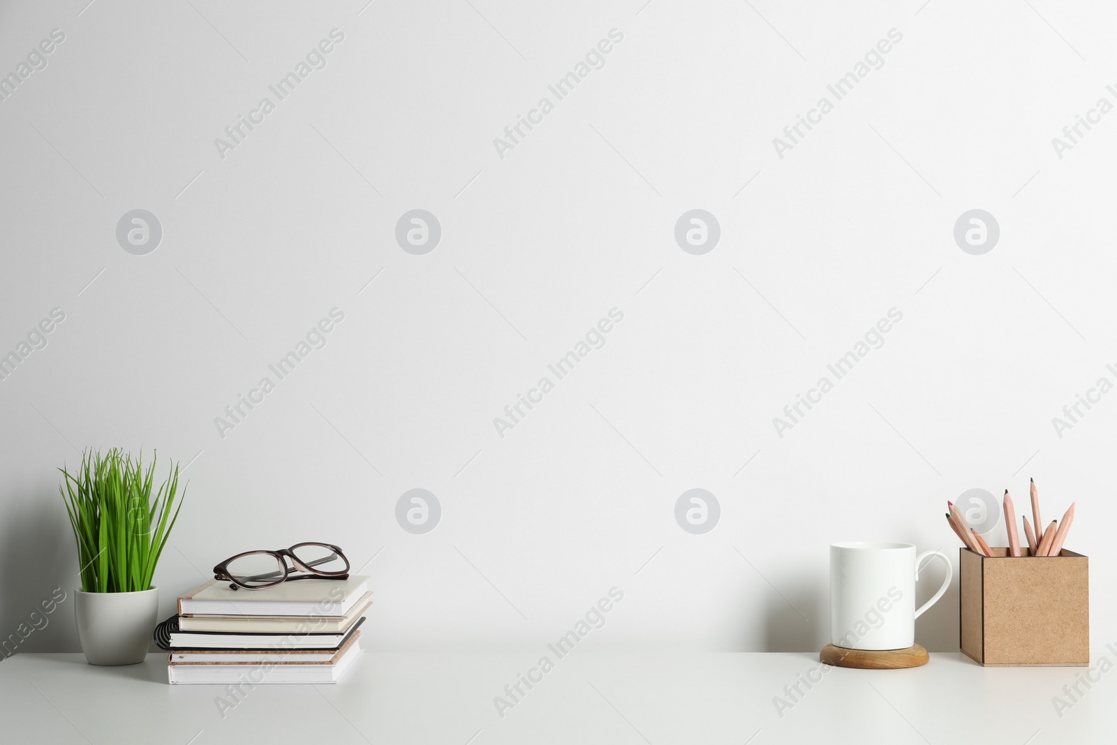 Photo of Comfortable workplace with white desk near wall. Space for text