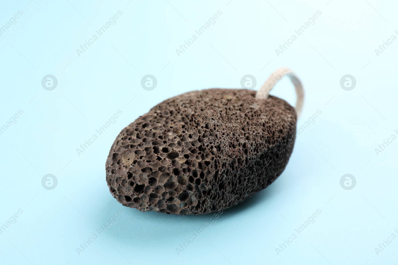 Photo of Pumice stone on light blue background. Pedicure tool