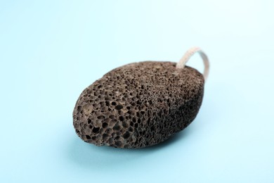 Pumice stone on light blue background. Pedicure tool