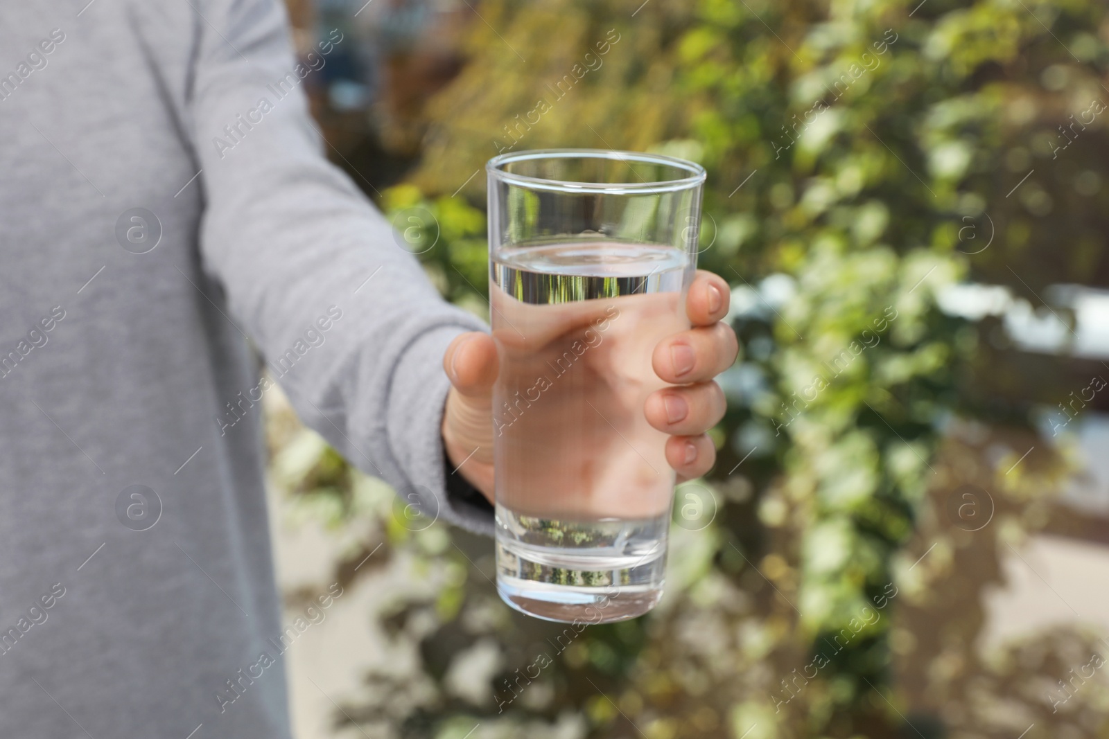 Photo of Woman holding glass of pure water, closeup