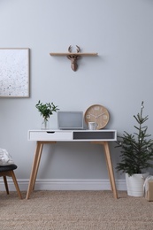 Stylish room interior with potted fir tree decorated for Christmas