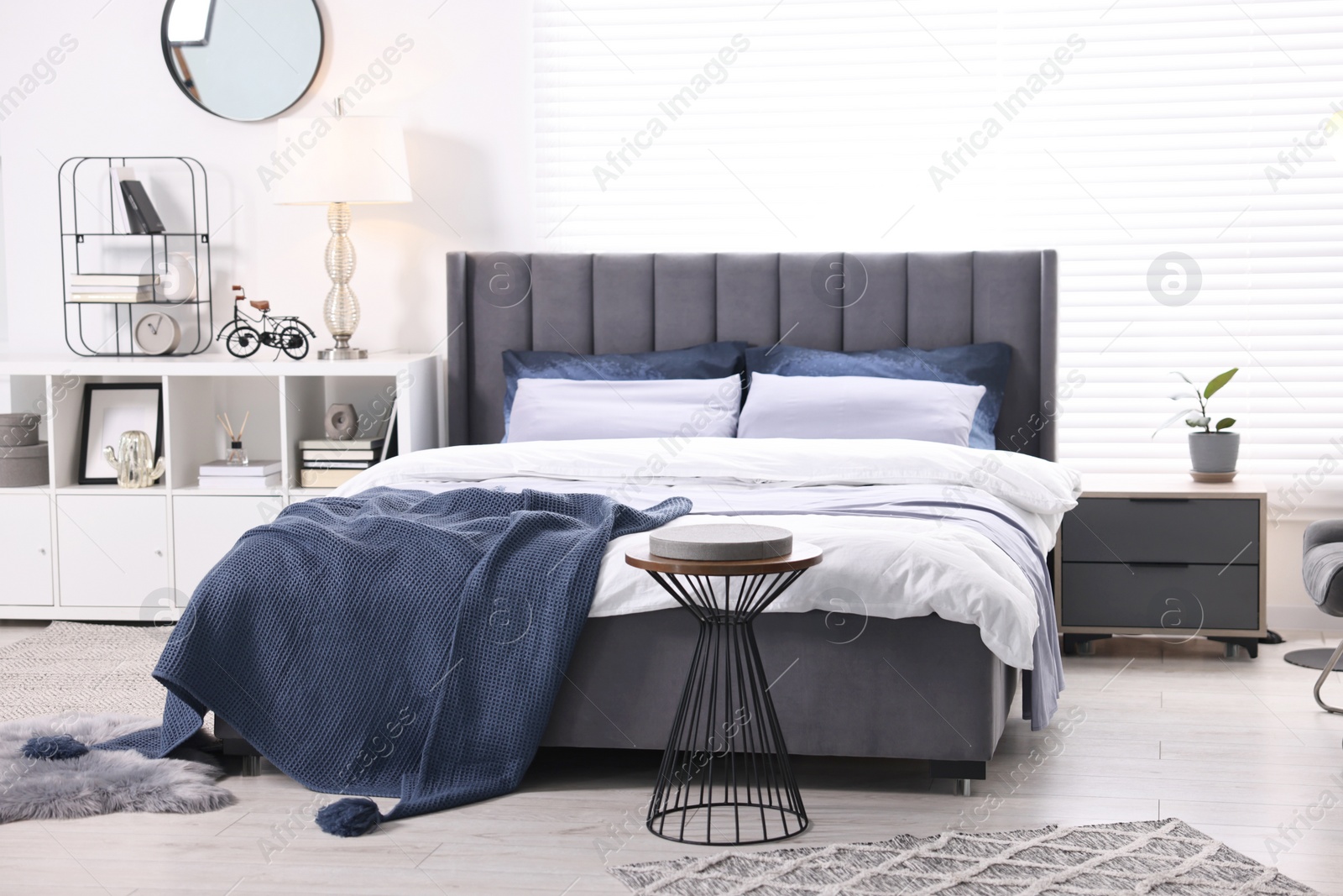 Photo of Bright plaid on bed in stylish bedroom. Interior design