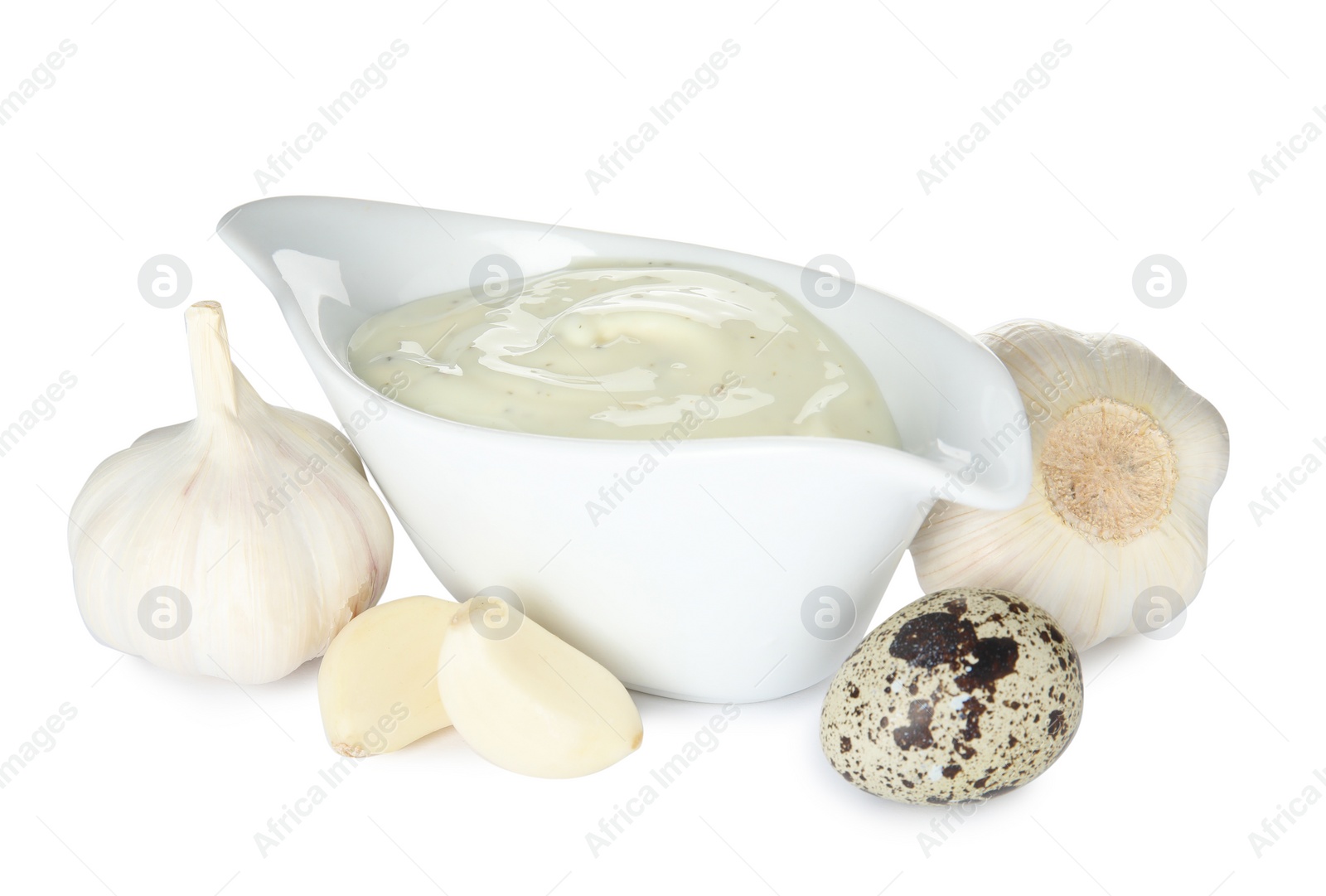 Photo of Gravy boat of sauce, garlic and quail egg isolated on white