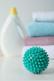 Photo of One turquoise dryer ball on white table