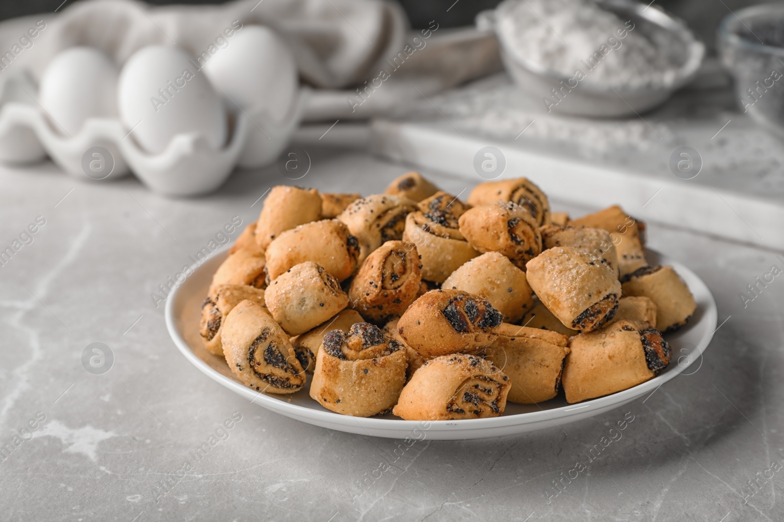 Photo of Tasty sweet cookies with poppy seeds on gray table